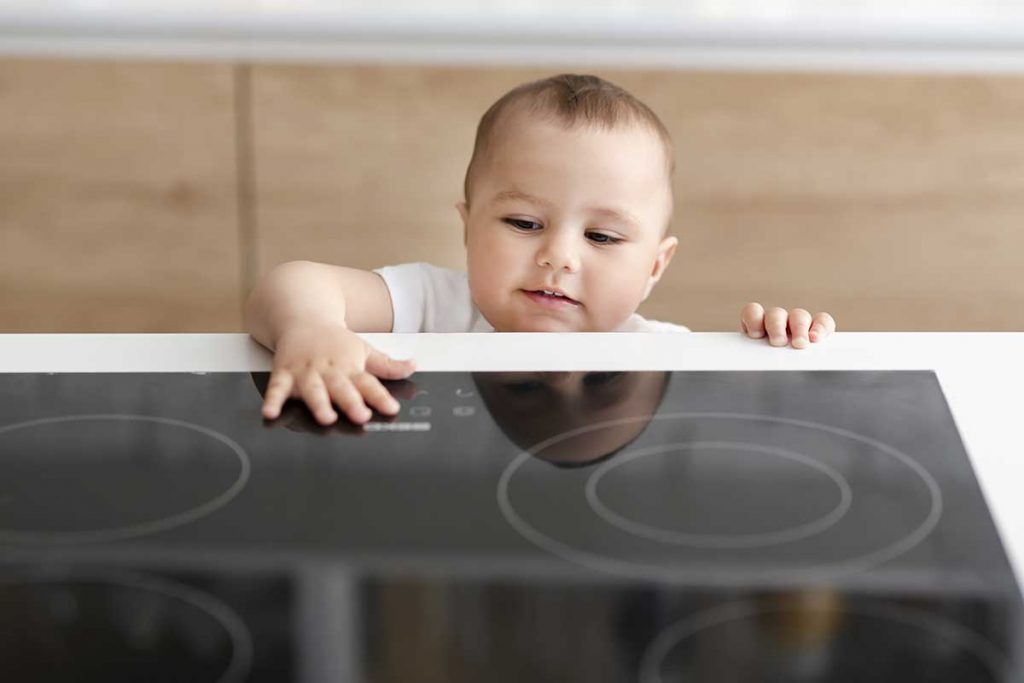child touching cool induction cook top