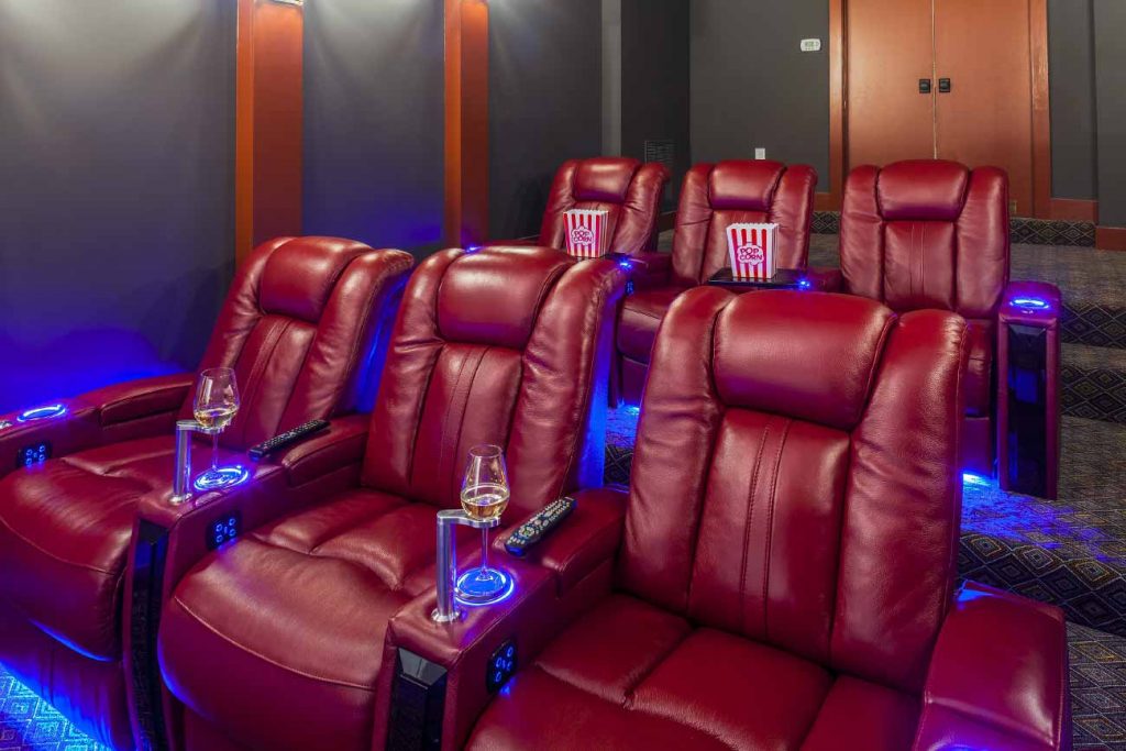 Home theater built by T.W. Ellis that includes large reclining theater seating with cup holders.