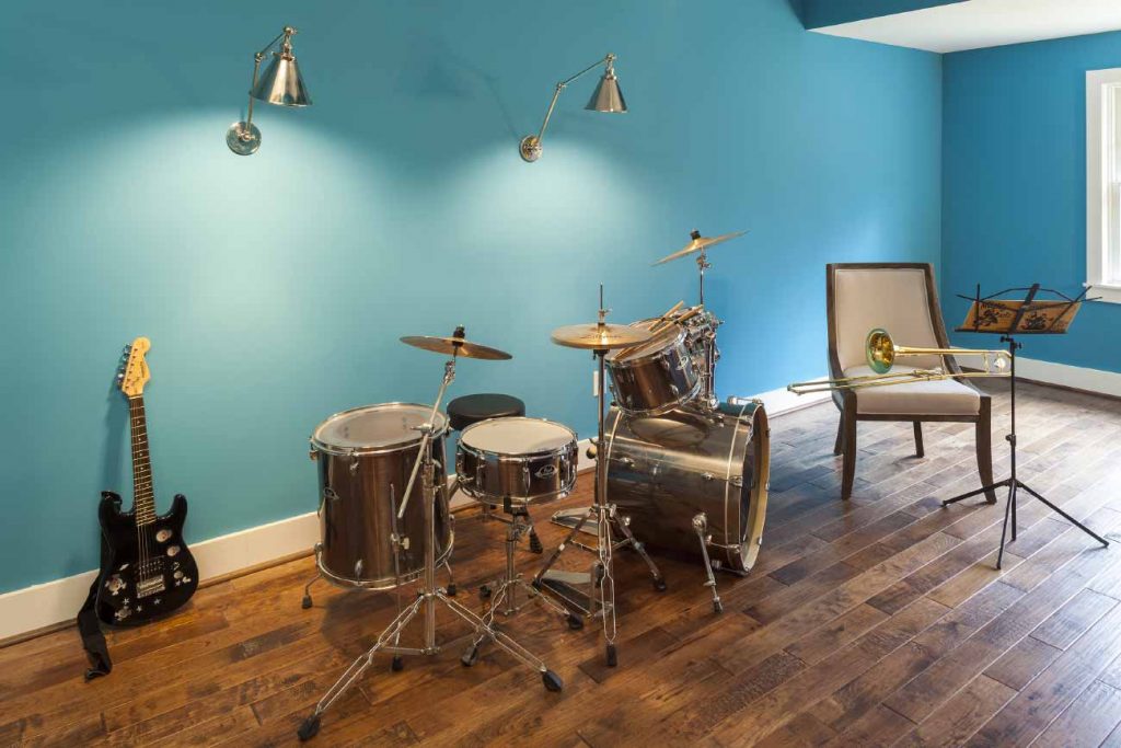 Music hobby room with drums, trombone, and an electric guitar.