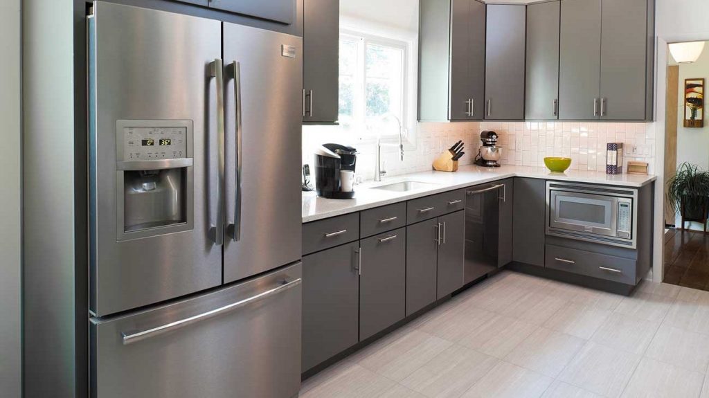 Modern kitchen renovated with vertical subway tile, solid surface counters, and tile floor