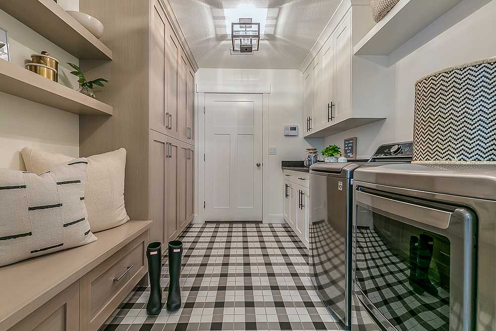 Attractive laundry room with cabinets and a bench