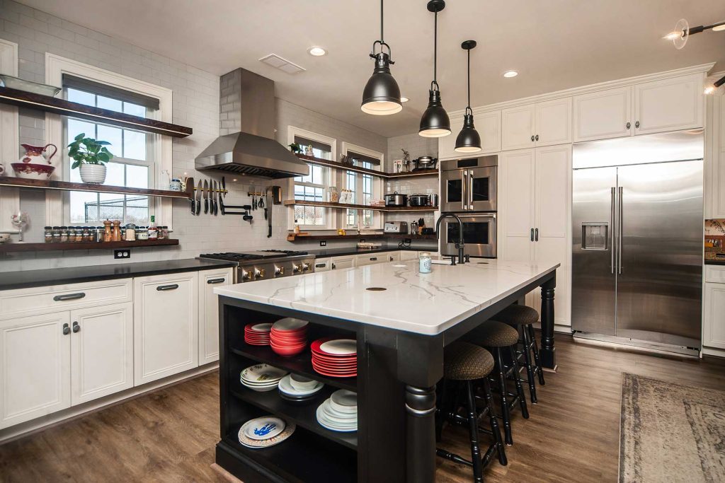 Industrial-style kitchen renovation with large sit-at kitchen island, open shelving, and all modern appliances.