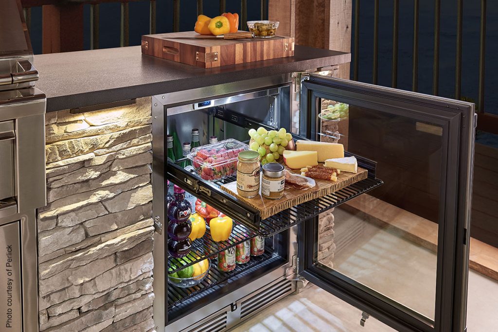 Under cabinet refrigerator in small luxury kitchen containing produce, beverages, and a charcuterie board