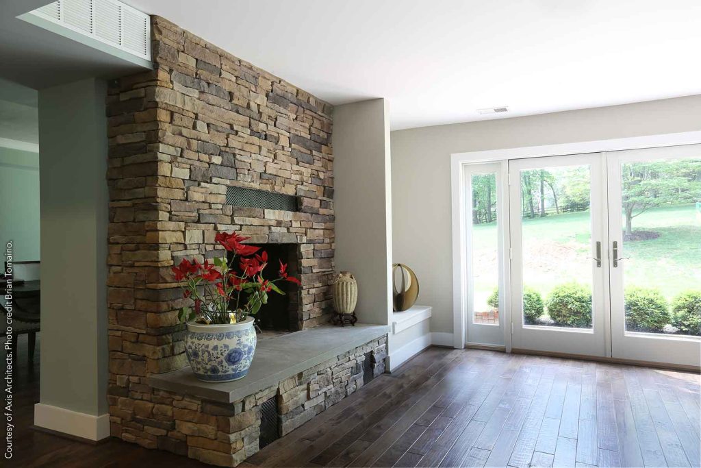 Fireplace with a stacked stone facade and slate slab for the hearth.