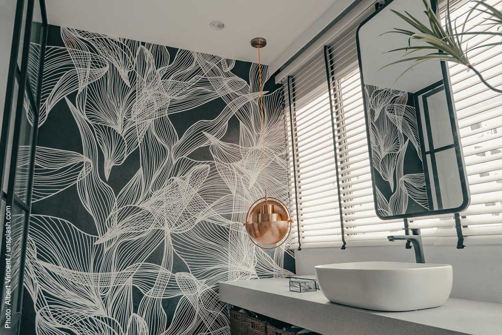 Bold powder room design with contour illustrations of flowers on a dark background wallpaper, a vessel style sink, and a floating mirror