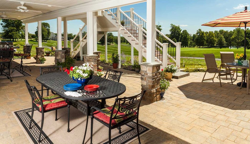Patio with raised deck overlooking a beautiful yard and golf course
