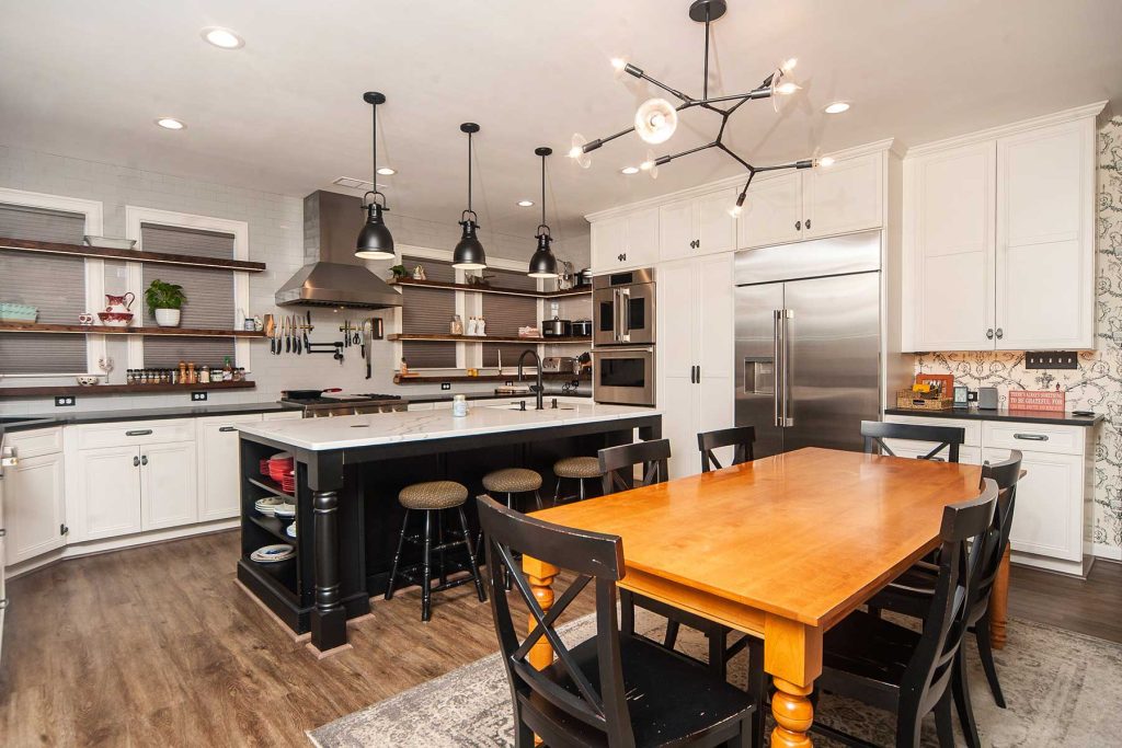 Industrial-style kitchen renovation created by T.W. Ellis includes large kitchen island and industrial appliances