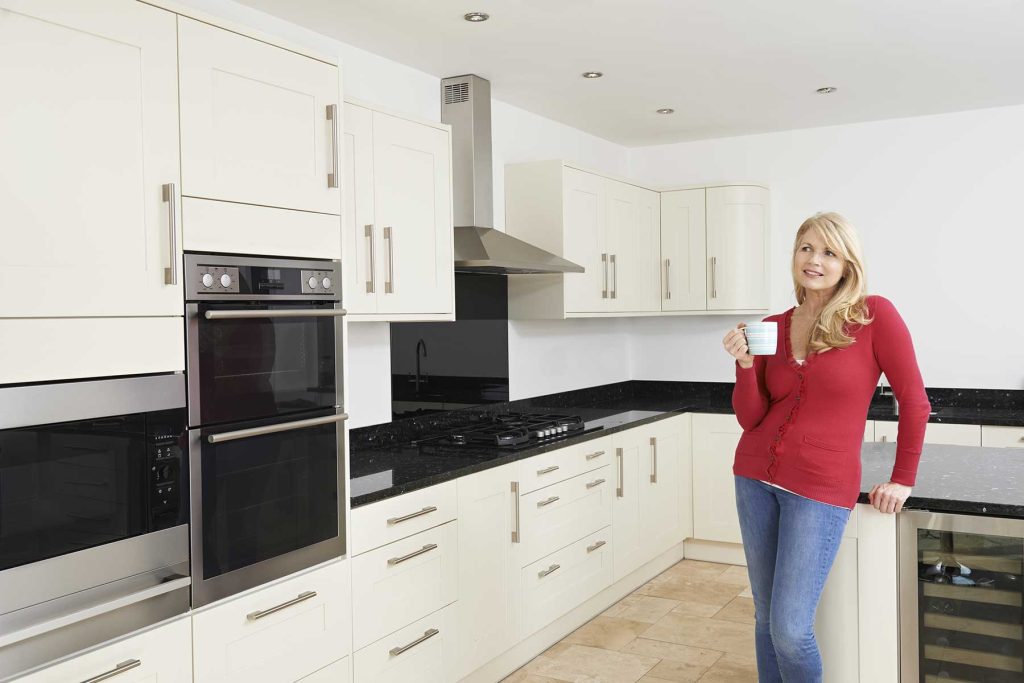 Woman admiring the success of her newly remodeled kitchen