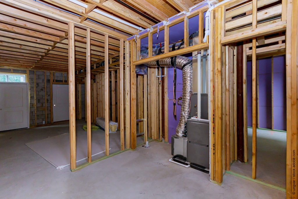 Interior view of a basement under construction home framing with beam in home heating system
