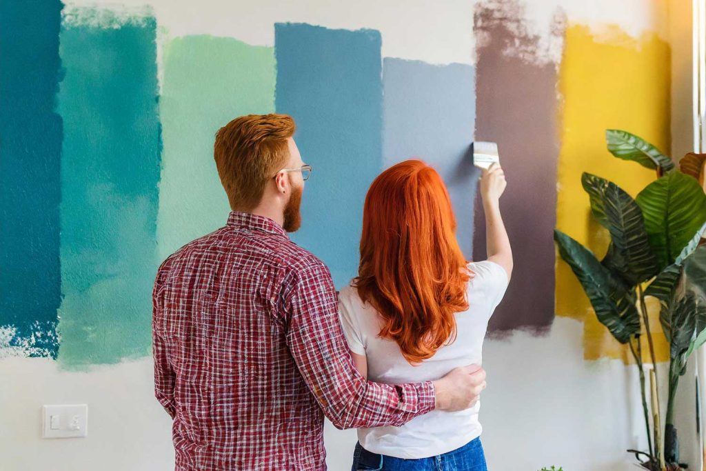 Young couple looking at paint samples while thinking about incorporating color into a home