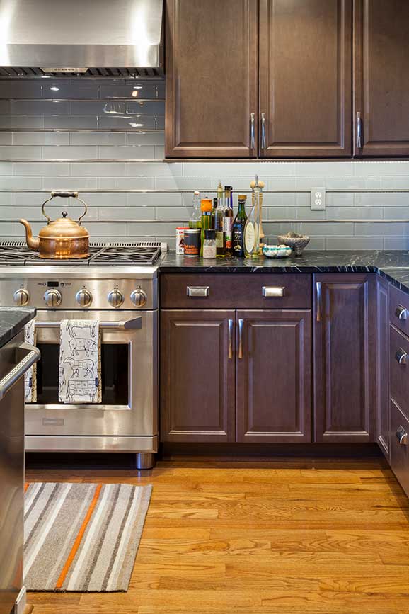 Kitchen cabinets, tile backsplash, and professional quality stove